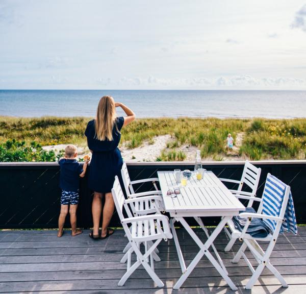 A mother and child looking at the water from a summer house on Djurland in East Jutland.