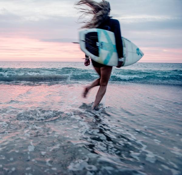 Surfer på stranden i Klitmøller Cold Hawaii på nordvestkysten av Danmark